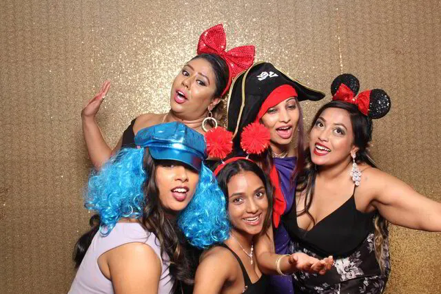 five women at a party posing in front of an oakville photo booth