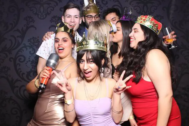 seven people posing infront of a photo booth with props in hamilton
