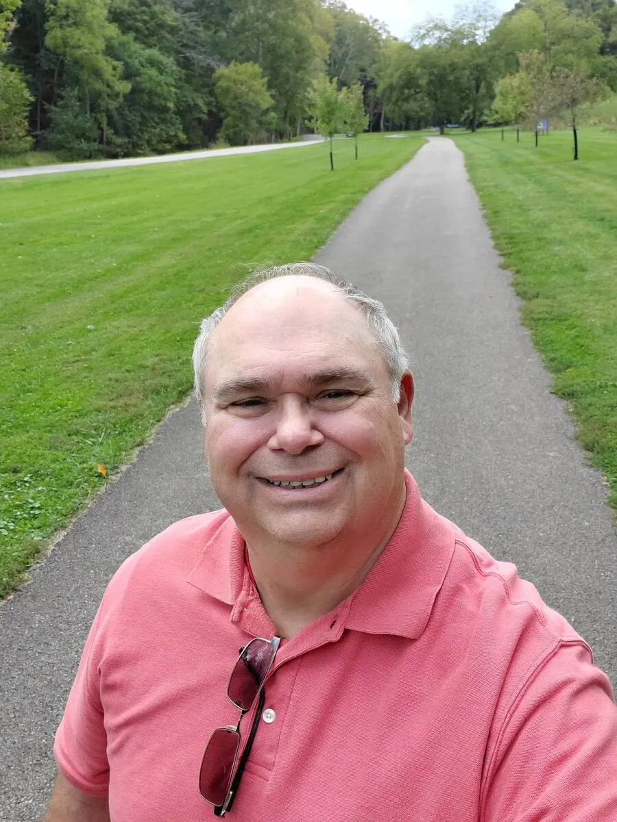 Roger Boothby smiling on a walking trail