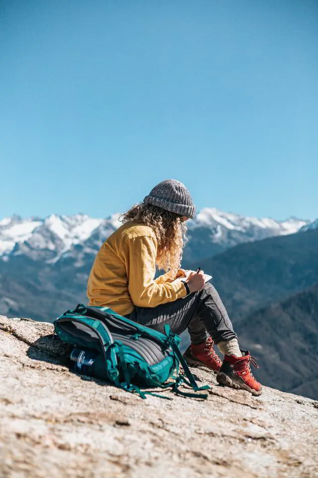 Woman writing content on a mountain