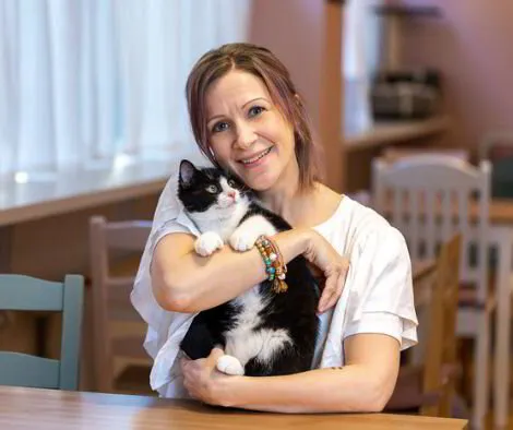 Bild på Alice, Vice VD:n på Purrfect Café, med en katt i famninen (Kapten Krok)