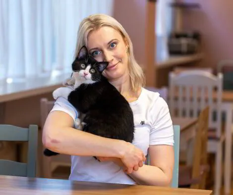 Bild på Rebecca, VD:n Purrfect Café, med en katt (Kapten Krok i famnen)
