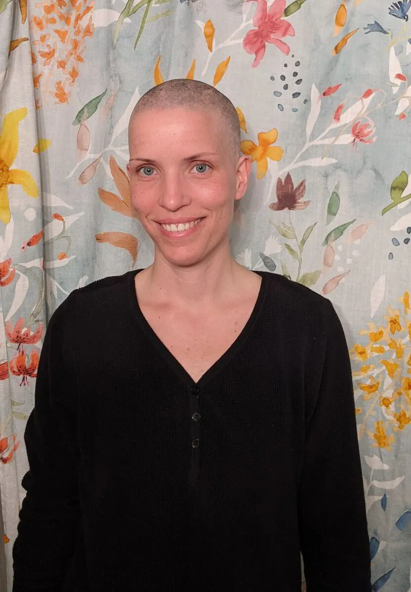 Caitriona Keown in black sweater against floral backdrop as she goes through cancer treatment