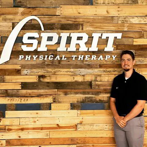 Dr. Worland next to Spirit Physical Therapy Sign