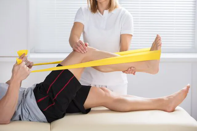physiotherapist helps patient regain knee strength