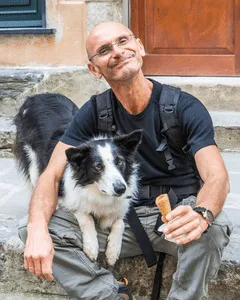Glücklicher Mann isst ein Eis mit Hund