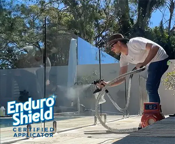 Applying EnduroShield after pool glass fence installation