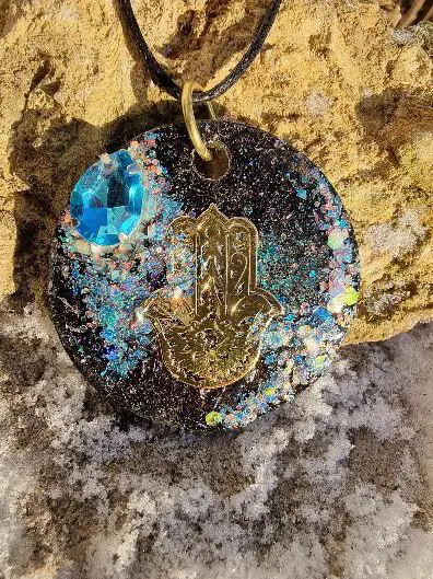 Halsband i svart, blå glaskristall, iriserande glitter och med Fatimas hand i guld