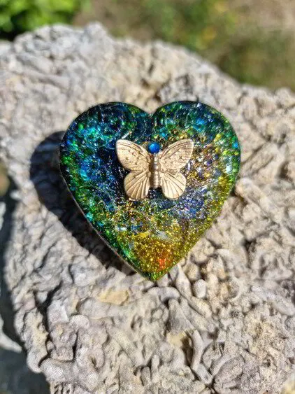 Mönstrat hjärta i guld, blågrönt och fjäril i guld med blå sten