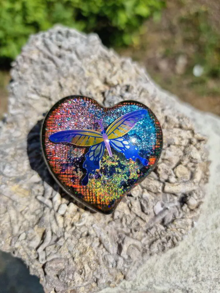 Mellanstort platt hjärta i iriserande färger med fjäril