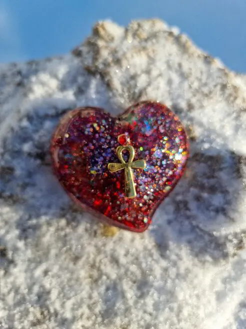 Mellanstort platt hjärta i silver, rött och ett fyrverkeri av färger och Ankh i guld