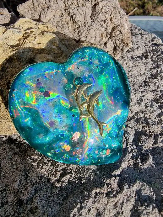 Stort platt hjärta i iriserande blåturkos med delfiner i guld och turkosblå kristall