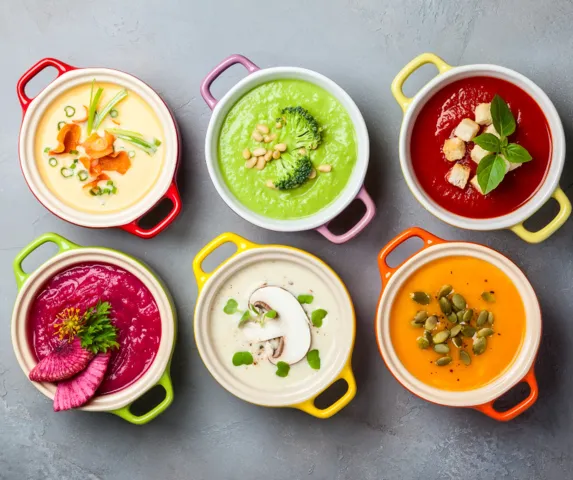 birds eye view of colorful soups in stockpots