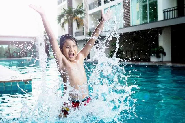 Happy kid playing in the water - splashing