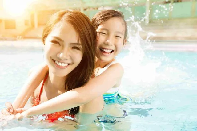 Parent and daughter enjoying playing in the water  - Family Swimming Lessons