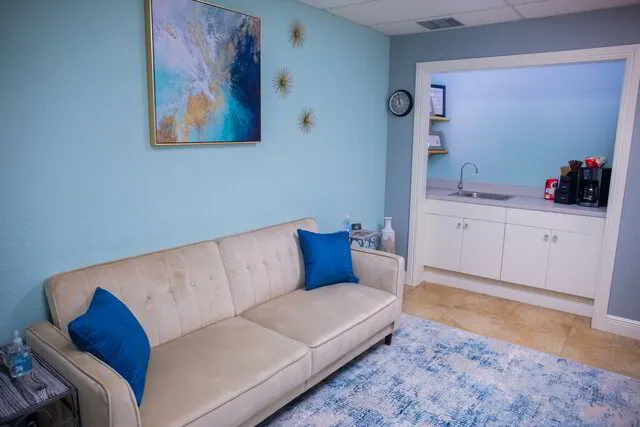 Palm Beach Therapeutic Massage's waiting room with couch and decor