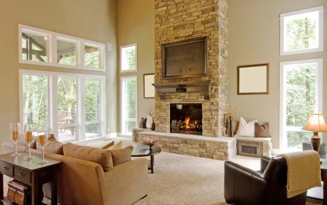 photo of living room with brick fireplace and large windows