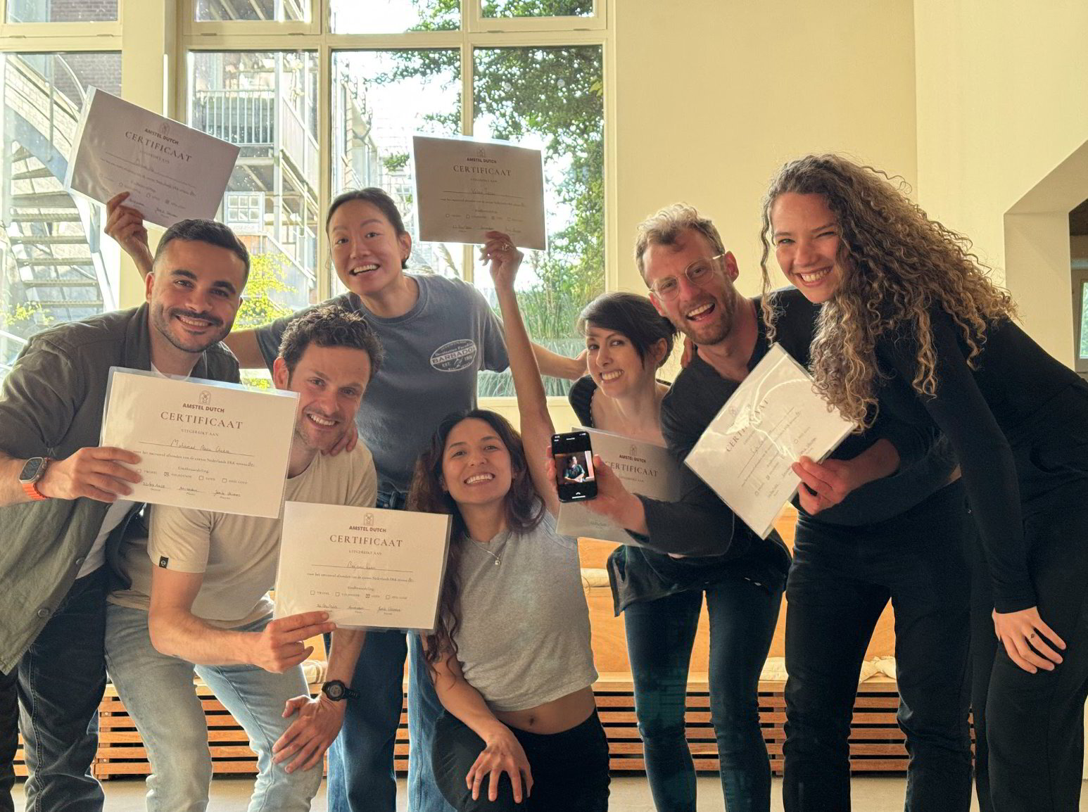 Happy Amstel Dutch students showing their certificates in class