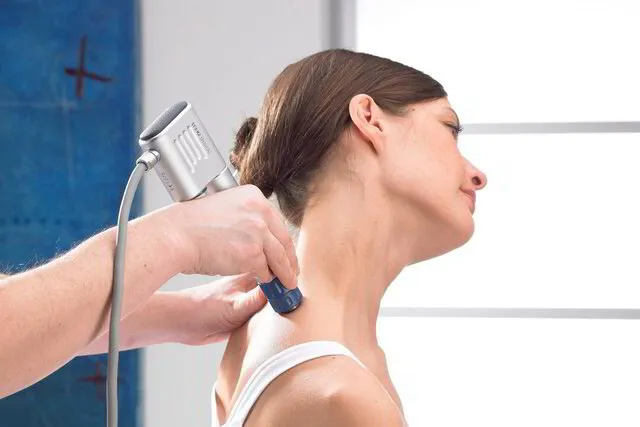 patient receiving shockwave therapy on upper shoulder