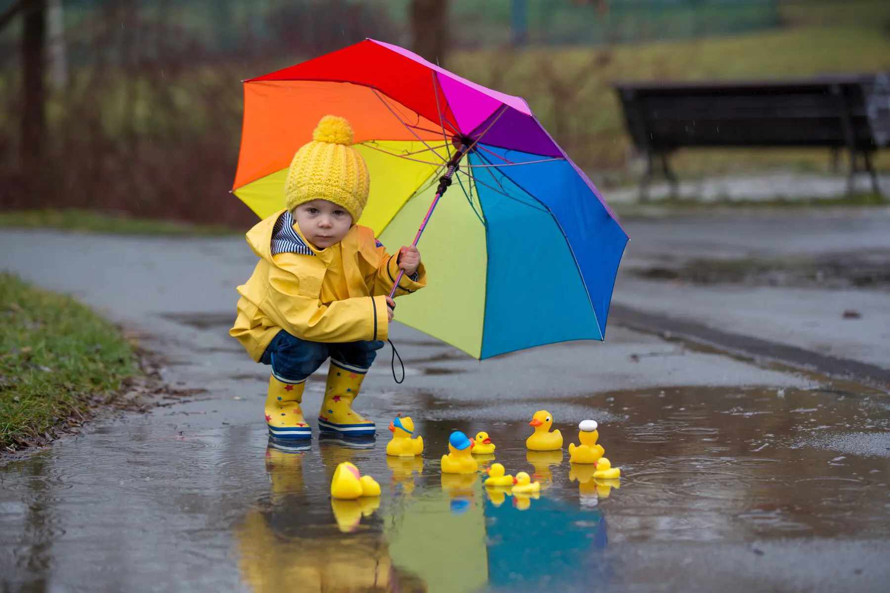 child with an umbrella and plastic ducks in puddles at Discovery Christian  Preschooll, Effingham IL