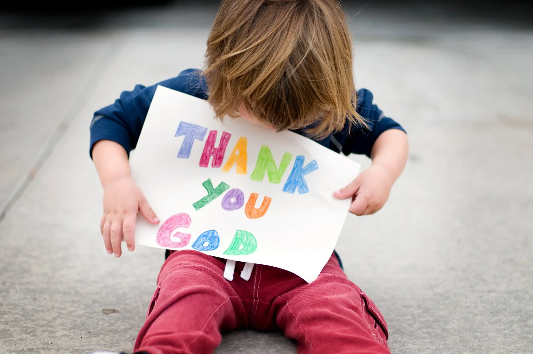 child holding a piece of paper that says thank you God at Discovery Christian Preschool in Effingham IL