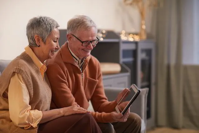Zwei ältere Personen, die auf ein iPad schauen.