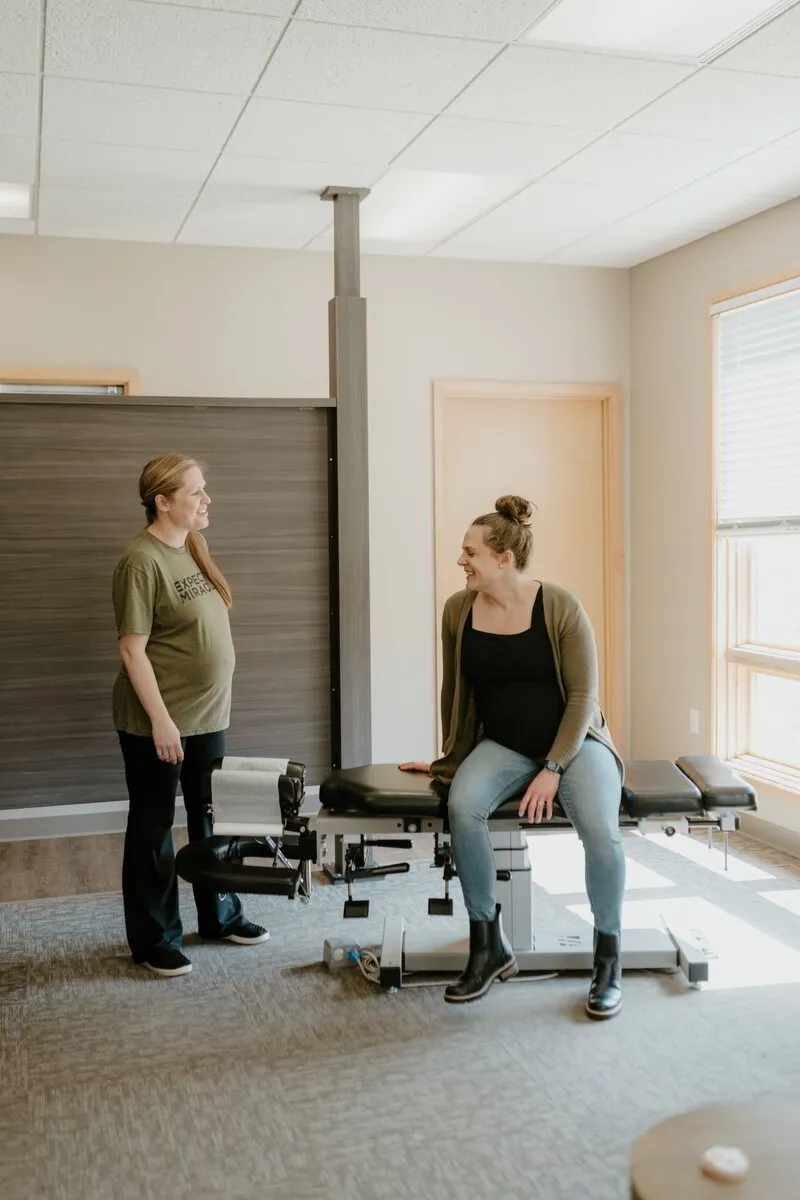Pregnant patient speaking with her chiropractor