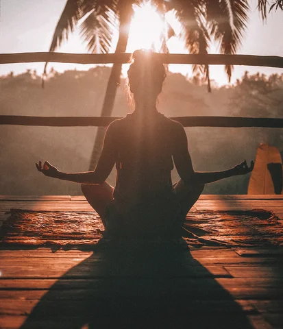 kvinna mediterar i solnedgången
