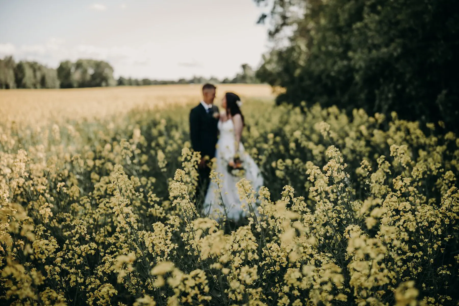 brudpar på blommig äng vid bröllopsfotografering
