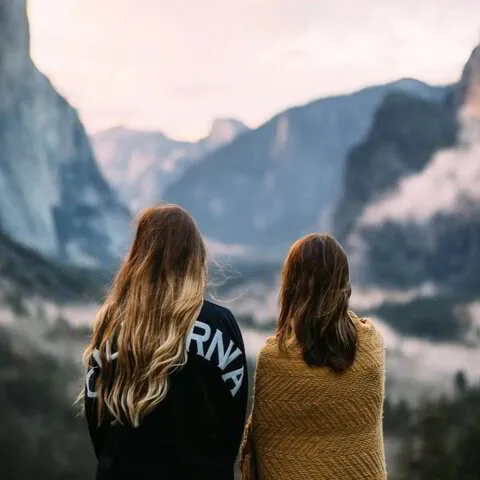 two woman looking at mountains