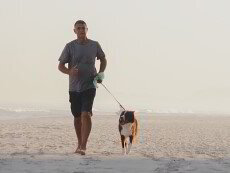 A man jogging with a dog