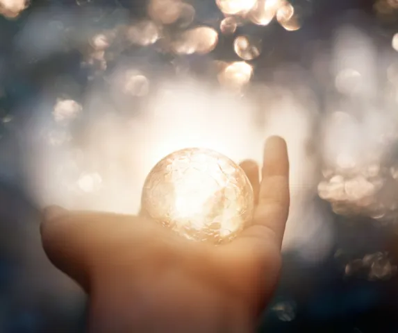 hand holding sparkly clear ball