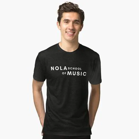 A man wearing a soft black tri-blend t-shirt with the NOLA School of Music logo