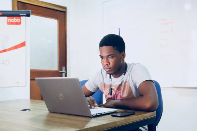 male student in a classroom using a laptop