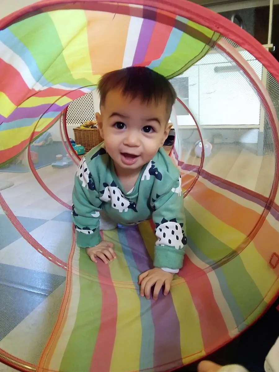 toddler crawling through play tunnel