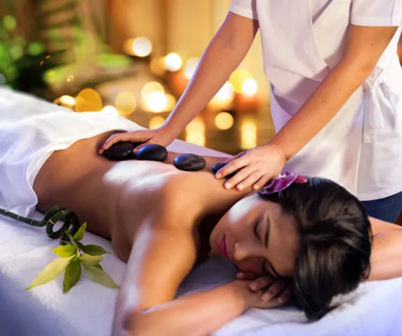 person receiving hot stone massage therapy