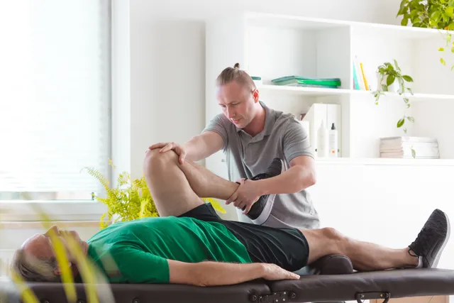 Physical therapist adjusting a patient's leg. Good in a Room helps PTs improve in-person communication.