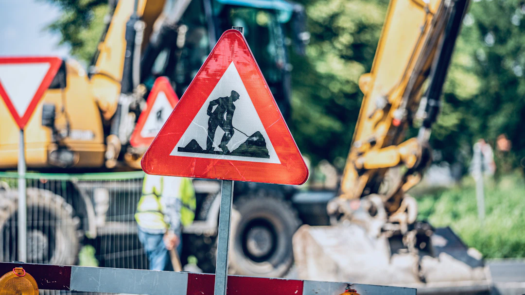 Road repair sign and asphalt crew