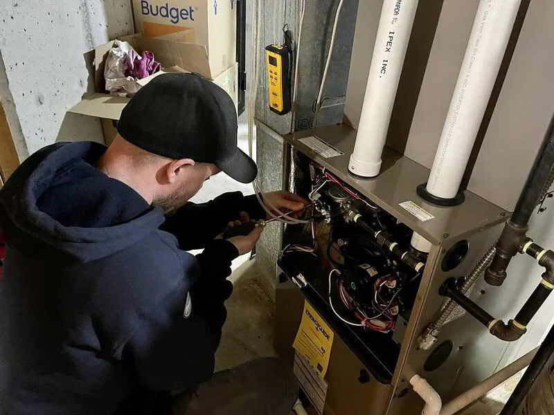 HVAC technician working on a central ducted heat pump system