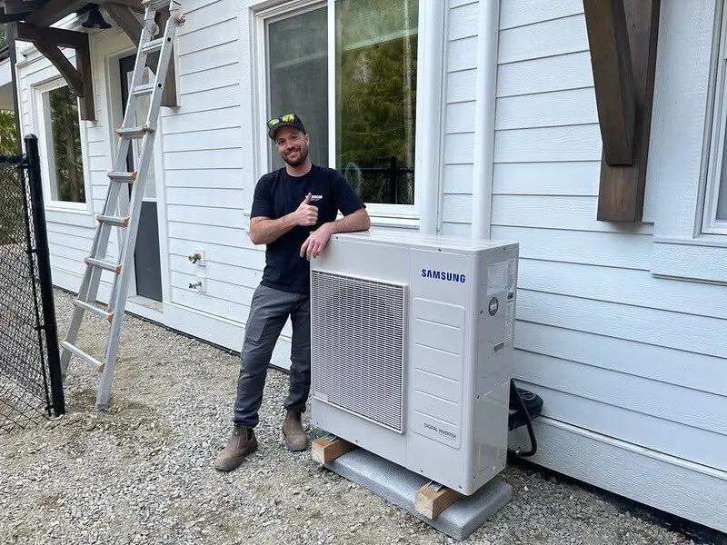 HVAC tech with a ductless heat pump after installation