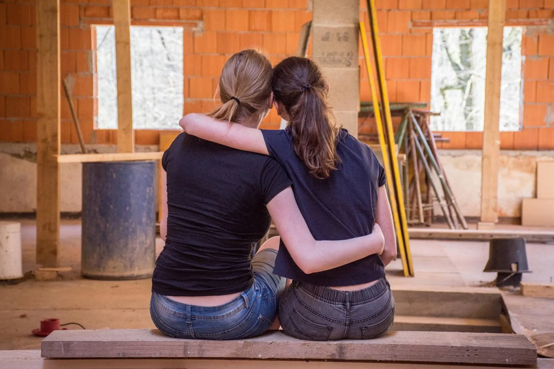 Two female home renovators sitting on a plank