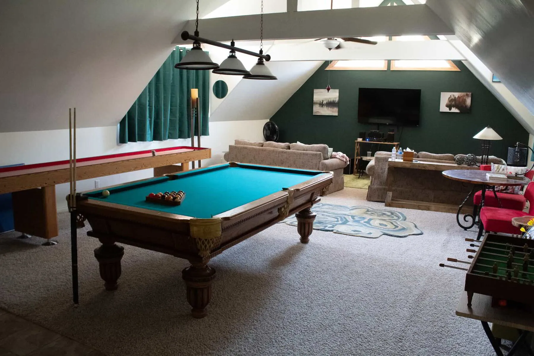 A game room with a pool table, arcade games, and a foosball table