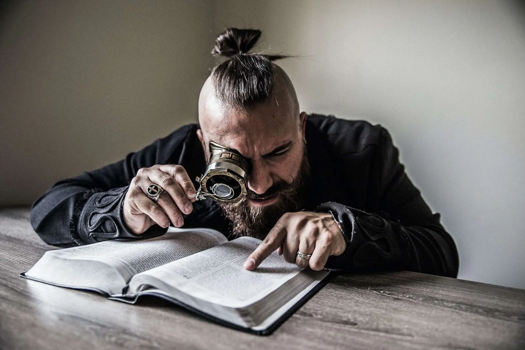 man reading a book with steam punk glasses