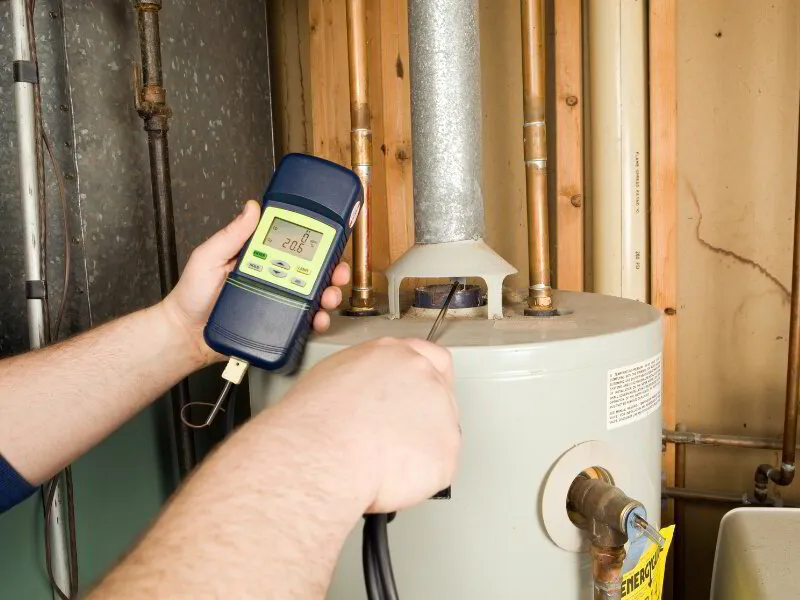 Repairman Checks Carbon Monoxide Level on Gas Water Heater Exhaust
