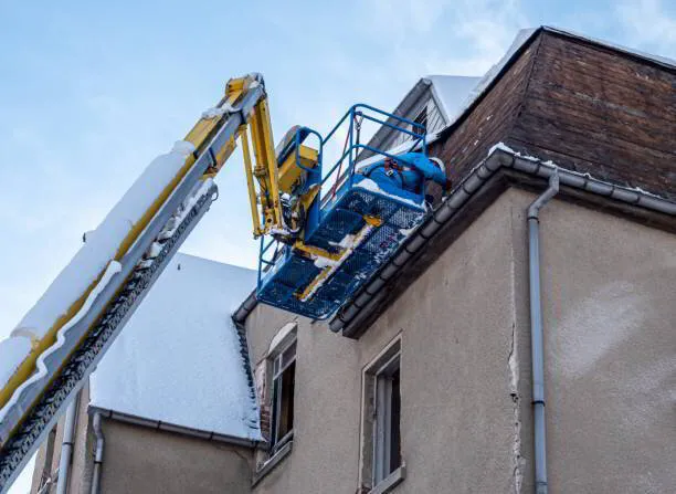 Aerial lift with man on the side of a house 