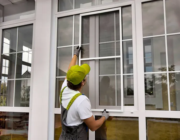 Man replacing new screen on outside of house