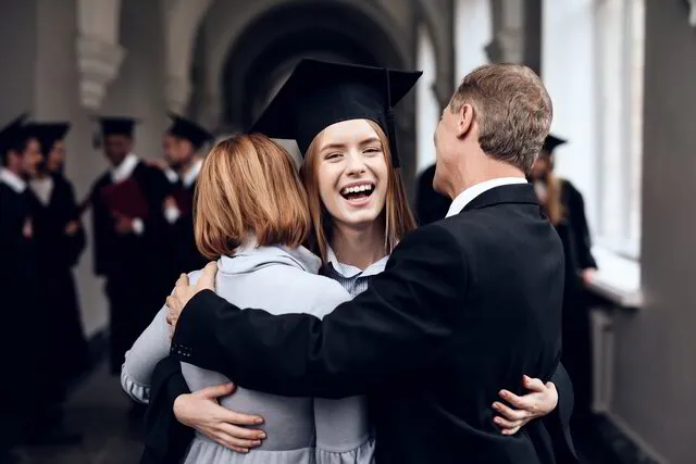 Proud parents hugging their college graduate child, funded by IUL for Kids policy