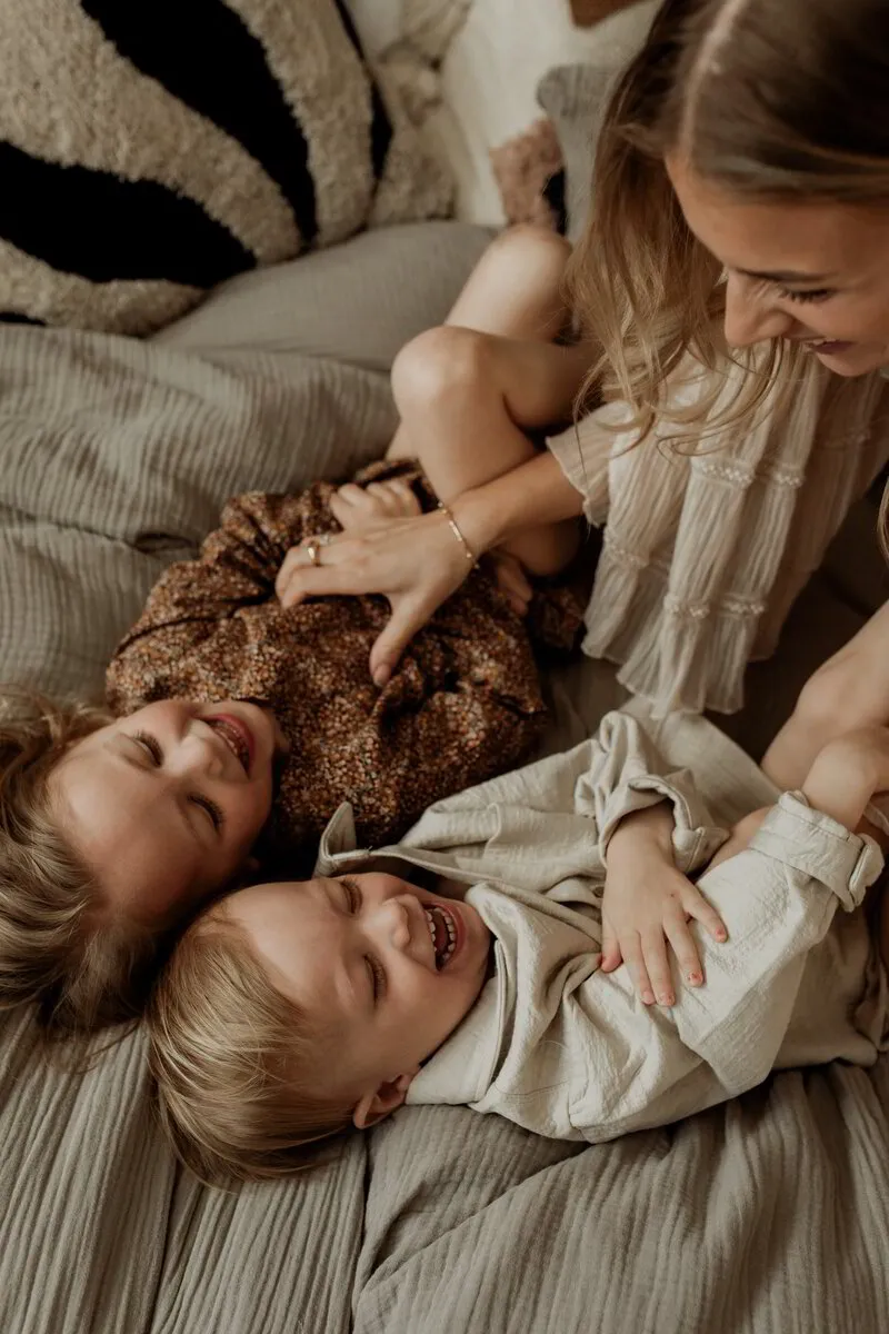 Andrea Norrman busar med hennes barn i sängen under en moderskapsfotografering 