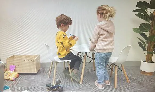 Two kids are drawing on a small table in Camberwell Podiatry Practice Clinic