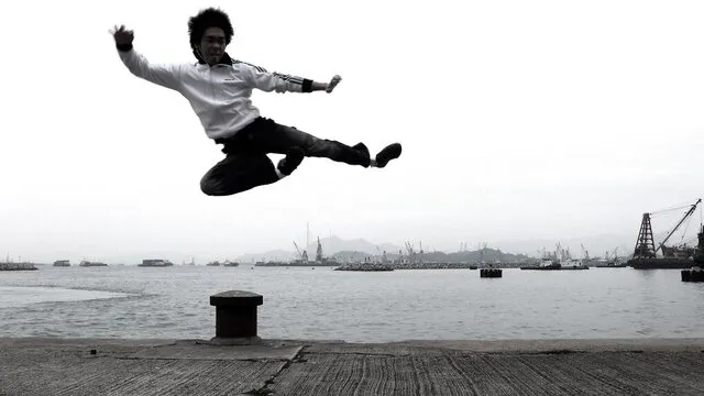 Albert Chan performing a flying kick at the Hong Kong harbour